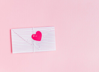 Valentine's Day. Love letter with red heart on pink background. top view .
