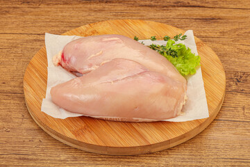 Raw chicken breast over board