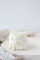 A fresh ricotta cheese on white wooden table
