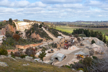 Trucks and machinery working at a stone quarry, exploitation of natural resources. Open air mining...
