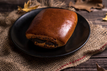 Autumn still life, fresh baked bun on wooden background