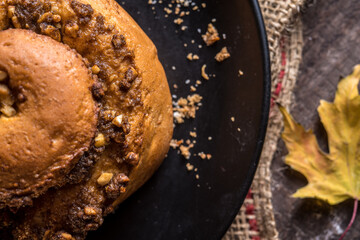 Autumn still life, fresh baked bun on wooden background