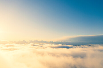 Aerial view gold sunrise over clouds in blue sky. Aerial top view cloudscape. Texture of clouds....