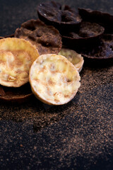 Chocolate coated hazelnut and rice florentines covered in cocoa powder.  White, milk and dark chocolate selection