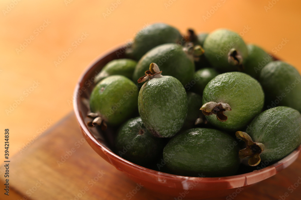 Wall mural feijoa in a bowl on a wooden background. close-up.