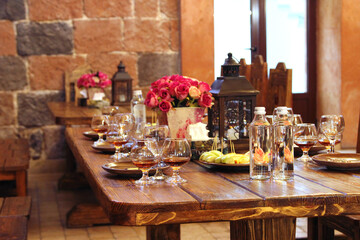 On the table there are glassware and a bouquet of flowers.