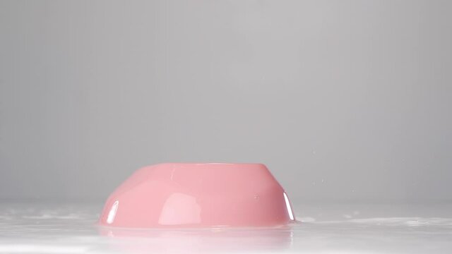 Pink jelly falling down. Falling jelly on white wet surface in slow motion.