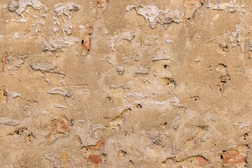 Wall with remnants of peeling tile, background or texture