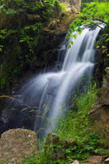 a vertical shot of a beautiful waterfall in the forest