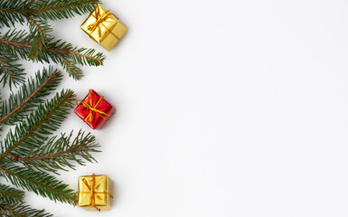 Christmas tree branches with yellow and red gifts on white background