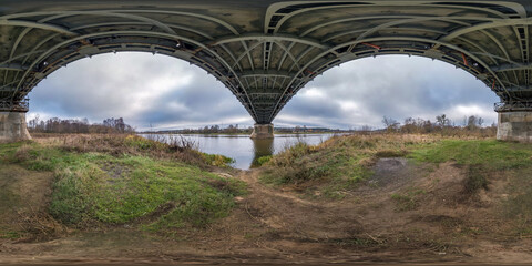 Fototapeta premium full seamless spherical hdri panorama 360 degrees angle view under steel frame construction of huge bridge across river in cloudy weather in equirectangular projection. VR AR content