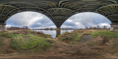 full seamless spherical hdri panorama 360 degrees angle view under steel frame construction of huge bridge across river in cloudy weather in equirectangular projection. VR  AR content
