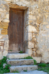 Fototapeta na wymiar An old wooden plank door in a stone wall