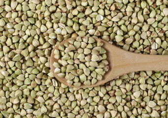Buckwheat and wooden spoon background and texture, top view