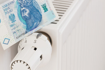 heating radiator and banknotes of 50 Polish zlotys. The concept of high costs of heating apartments