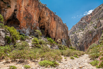 Rocks of the gorge with a cave against the sky