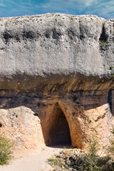 Entrance to grotto in a rocky wall in La Ciudad Encantada of Cuenca, Spain