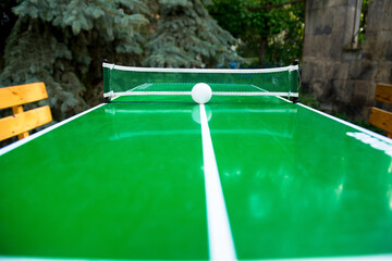 Table tennis game and a ball on green tennis board