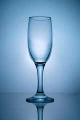 Empty champagne glass on blue background