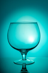Empty large glass on a blue (azure) background with a gradient