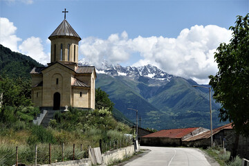 Georgian Orthodox Church in the foreground and the mountains of the Svanetian region in the background.