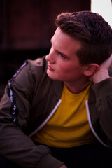 Obraz premium A young man sitting on the railways and looking forward.