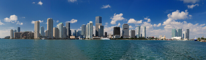 Fototapeta na wymiar Panoramic View To The Skyline Of Miami From A Vessel On A Sunny Autumn Day With A Clear Blue Sky And A Few Clouds