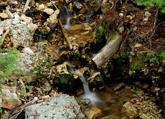 Long Time Exposure Of Flowing Water At Red Rock Point Yellowstone National Park On A Sunny Summer Day With A Clear Blue Sky And A Few Clouds