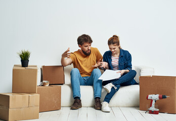 Man and woman in new room stuff in boxes moving family interior