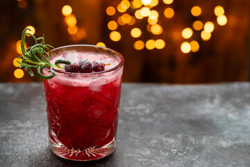 Christmas cranberry cocktail with lights in the background