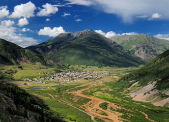 Obraz premium Aerial View From The Million Dollar Highway To Silverton Colorado Surrounded By Mountains On A Sunny Summer Day With A Clear Blue Sky And A Few Clouds
