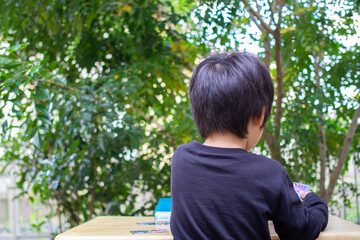 シマトネリコの木のある庭で遊ぶ日本人の子供