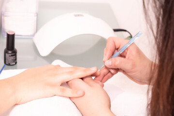 mujer haciendo la manicura y pintándose las uñas en un salon de belleza