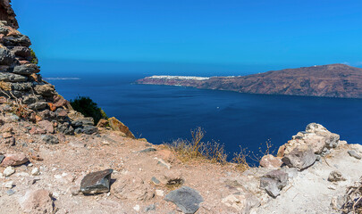 Fototapeta na wymiar The rocky foreground of Skaros Rock in front of the caldera view towards Oia in summertime