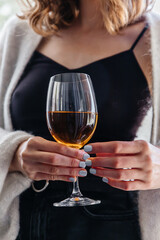 wine in a glass in the hands of a young girl