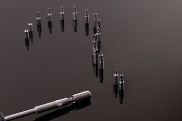 Question concept, question mark with set of various hexagonal star bits for screwdriver on black reflection background