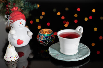 Christmas Concept with herbal tea. Christmas Tree, Ornaments and Defocused Lights.