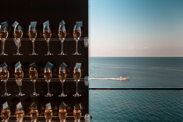 Glass of champagne on sunset with a seaview with yacht boat
