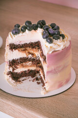 Sliced ​​sponge cake with blueberries on a wooden table