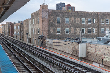 Fototapeta na wymiar Elevated subway tracks running alongside vintage brick buildings in urban Chicago