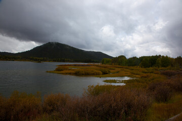 Mountains with clouds and a river in the foreground