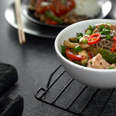  Soba noodles with chicken, hot pepper, zucchini, mushrooms, green onions on the   dark background. Selective focus. Asian food