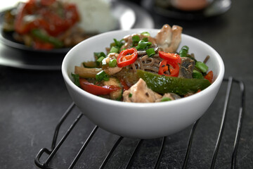  Soba noodles with chicken, hot pepper, zucchini, mushrooms, green onions on the  dark  background. Selective focus. Asian food