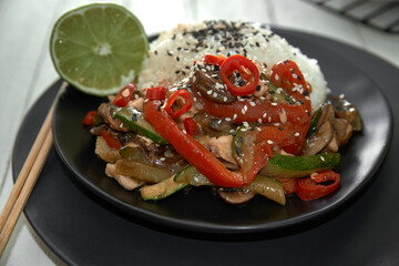 Chicken teriyaki on rice and vegetables, Japanese food on black background