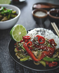 Chicken teriyaki on rice and vegetables, Japanese food on black background