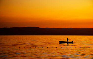 Image of a fishing boat against the sunset background