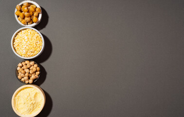 Raw and cooked chickpeas, chickpea flour and flakes in small ceramic plates, on a black background. Protein dish. style minimalism. healthy vegetarian food concept