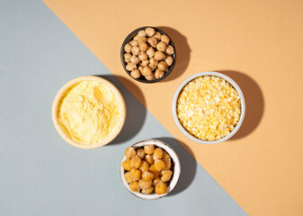 Vegetarian Raw and cooked chickpeas, chickpea flour and flakes in small ceramic plates, isometric projection diagonal beige and blue background.