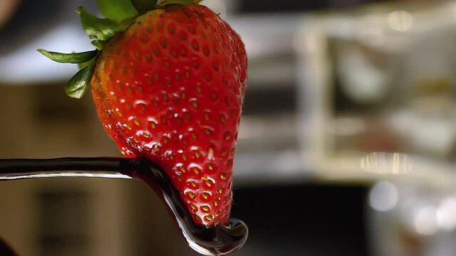 Strawberry rotating is drizzled with chocolate