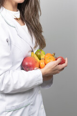 Female nutritionist in her office,  showing healthy vegetables and fruits. Healthcare and diet concept. Lifestyle.